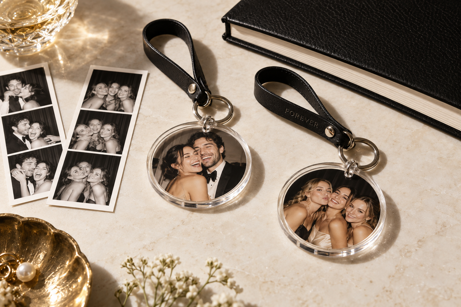 Illustrative concept of round photo keychains with leather wristbands beside prints and a guestbook